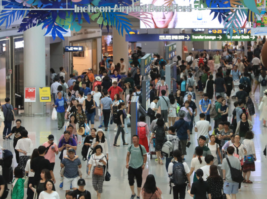 인천공항 북적      (영종도=연합뉴스) 서명곤 기자 = 본격적인 휴가철을 맞아 26일 오전 인천국제공항 면세구역이 여행객들로 붐비고 있다. 2018.7.26      seephoto@yna.co.kr  (끝)